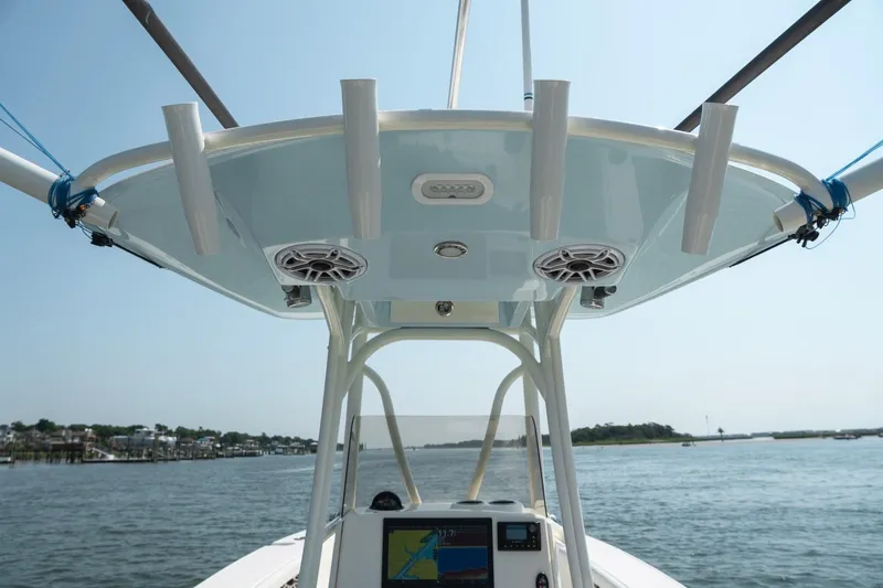 Slide: The Image of 2024 Pathfinder 2700 Open boat console with speakers and rod holders on a sunny day. - 20