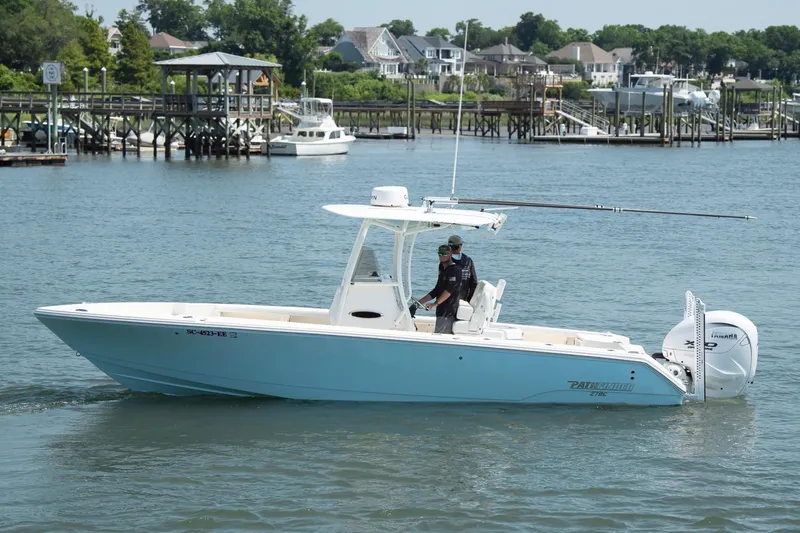 Slide: The Image of 2024 Pathfinder 2700 Open boat cruising on a scenic waterfront with docks and houses. - 4