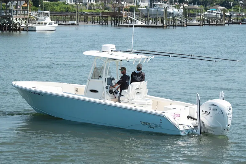 Slide: The Image of 2024 Pathfinder 2700 Open boat cruising on a calm waterway near docks. - 8