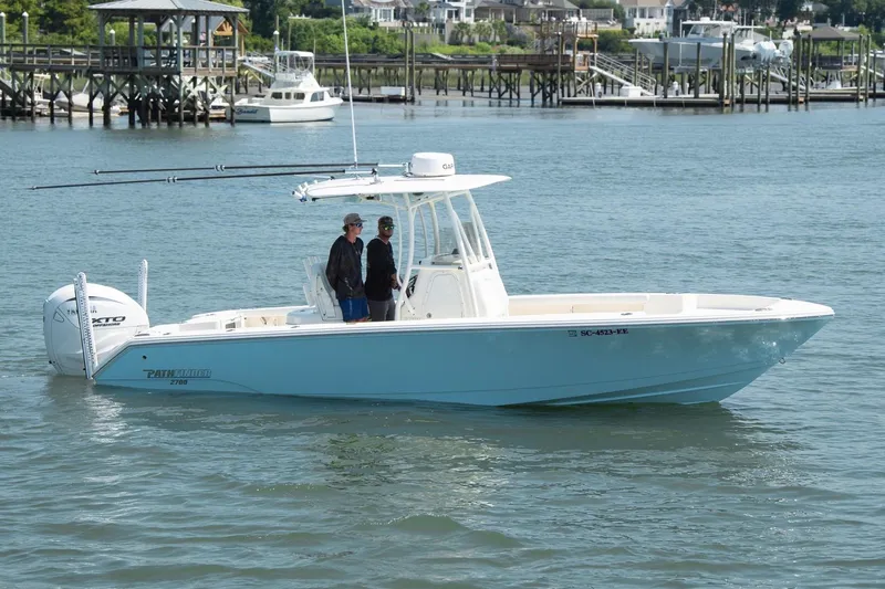 Slide: The Image of 2024 Pathfinder 2700 Open boat cruising on a calm waterfront with two passengers. - 9