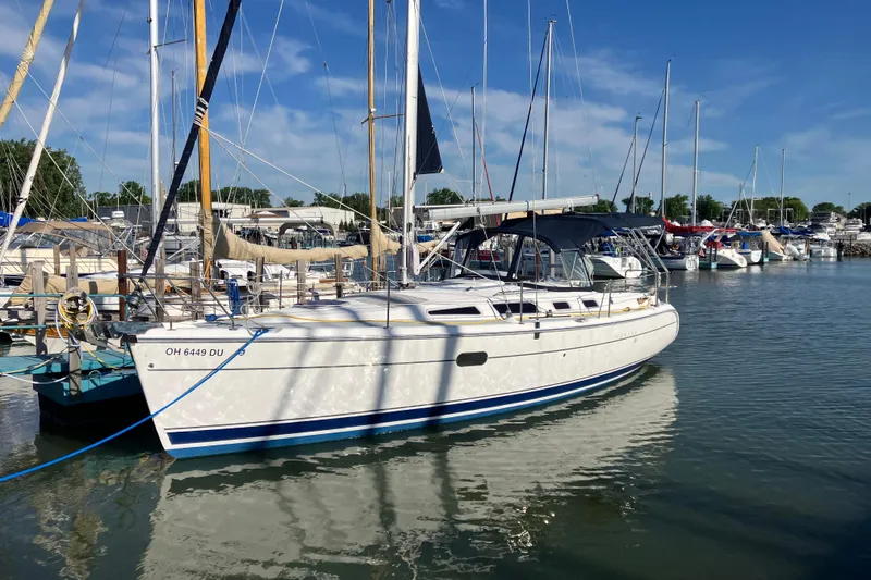 The Image of 2005 Hunter 36 sailboat docked in a marina under a clear blue sky. - 0