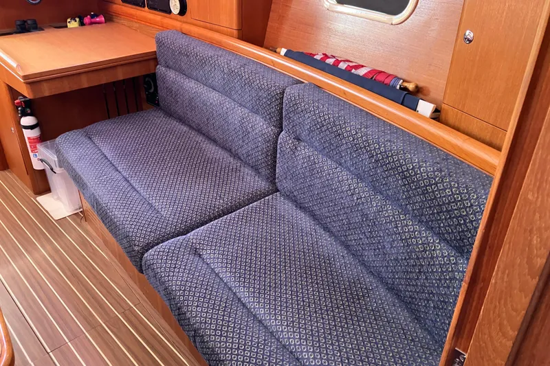 Slide: The Image of Interior of a 2005 Hunter 36 sailboat with blue patterned seating and wooden accents. - 40