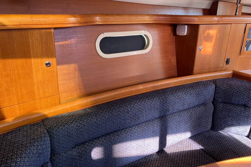 Slide: The Image of Interior of a 2005 Hunter 36 sailboat with wooden cabinetry and blue cushioned seating. - 42