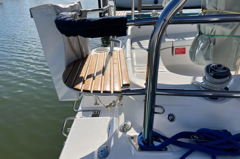 Slide: The Image of Cockpit of a 2005 Hunter 36 sailboat with wooden seating and stainless steel railings. - 10