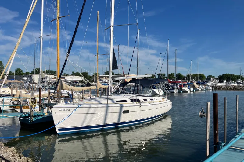 Slide: The Image of 2005 Hunter 36 sailboat docked in a marina under a clear blue sky. - 3