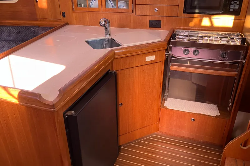 Slide: The Image of Hunter 36 yacht kitchen interior with stove, sink, and wooden cabinetry, 2005 model. - 30