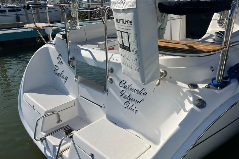 Slide: The Image of 2005 Hunter 36 sailboat docked at Catawba Island, Ohio, featuring "Om Belay" name. - 12