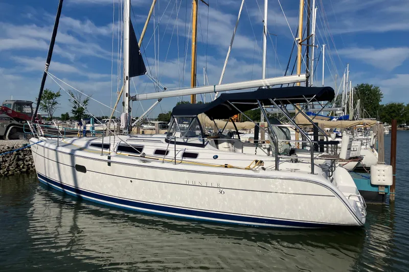 Slide: The Image of 2005 Hunter 36 sailboat docked at a marina under a clear blue sky. - 2