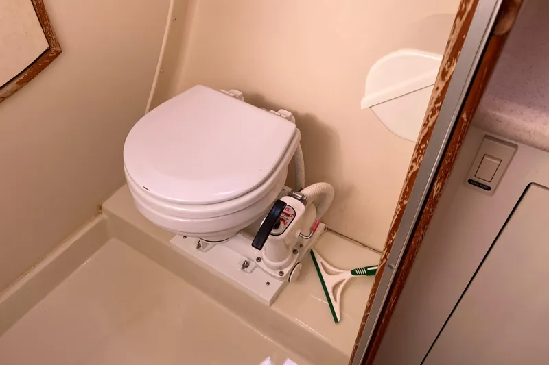 Slide: The Image of Marine toilet in a 2005 Hunter 36 sailboat bathroom, featuring manual pump system. - 51