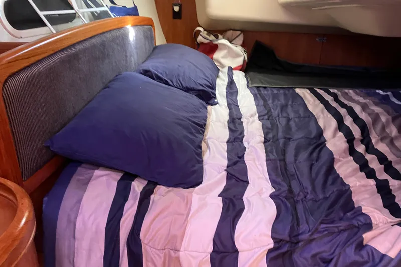 Slide: The Image of Cozy cabin bed in a 2005 Hunter 36 sailboat with striped bedding. - 45