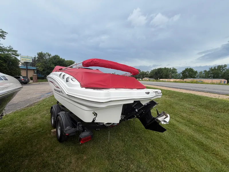 Slide: The Image of A 2012 Chaparral 206 SSi boat with a red cover on a trailer on grass. - 5