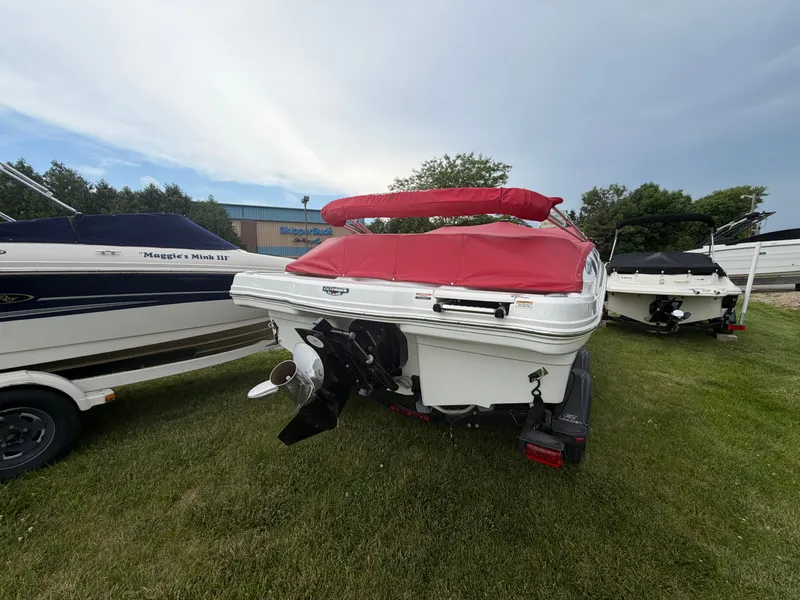 Slide: The Image of A 2012 Chaparral 206 SSi boat on grass, featuring a red cover. - 4
