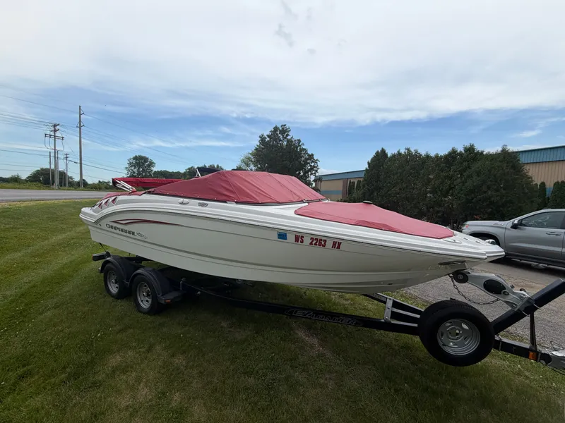 Slide: The Image of A 2012 Chaparral 206 SSi boat on a trailer, parked on grass. - 2