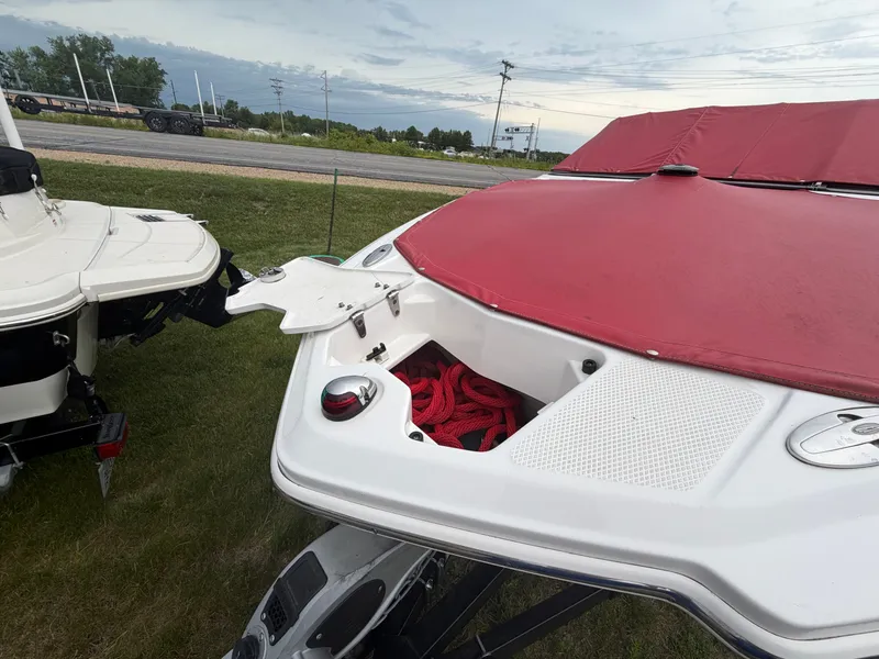 Slide: The Image of A 2012 Chaparral 206 SSi with a red cover, parked on a trailer. - 10