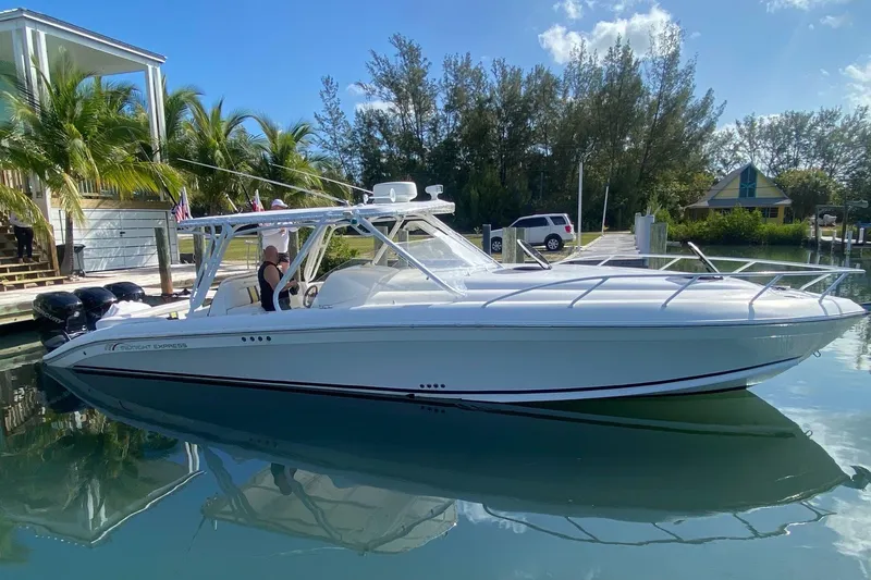 The Image of 2008 Midnight Express 37 Cabin boat docked, surrounded by palm trees and clear skies. - 0