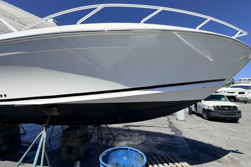Slide: The Image of 2008 Midnight Express 37 Cabin boat on dry dock, with white hull and blue sky background. - 10