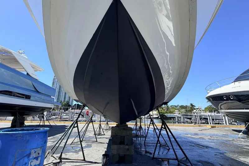Slide: The Image of 2008 Midnight Express 37 Cabin boat on dry dock, viewed from below, with clear blue sky. - 12