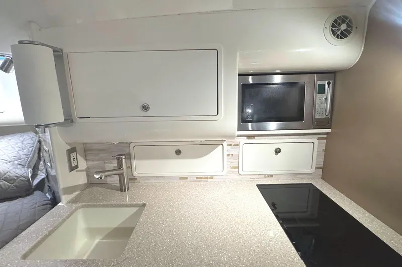 Slide: The Image of Compact kitchen in 2008 Midnight Express 37 Cabin with sink, microwave, and stove. - 6