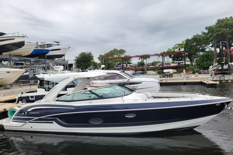 The Image of 2019 Formula 350 Crossover Bowrider docked at a marina, surrounded by other boats. - 0