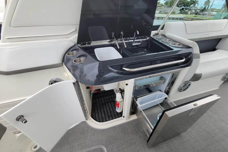 Slide: The Image of 2019 Formula 350 Crossover Bowrider boat interior with kitchenette and seating area. - 12