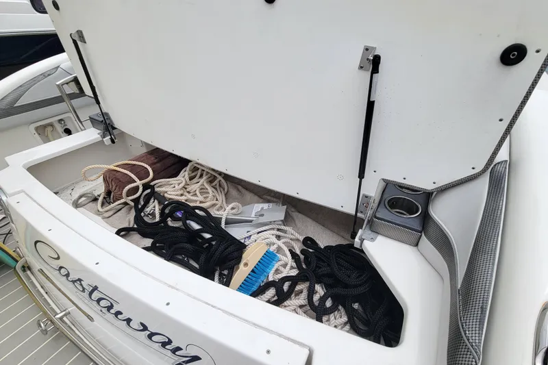 Slide: The Image of Open storage compartment on 2019 Formula 350 Crossover Bowrider with ropes and cleaning brush. - 6