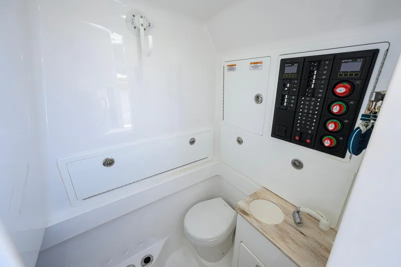 Slide: The Image of 2023 Valhalla V-37 boat interior with control panel and compact bathroom amenities. - 58