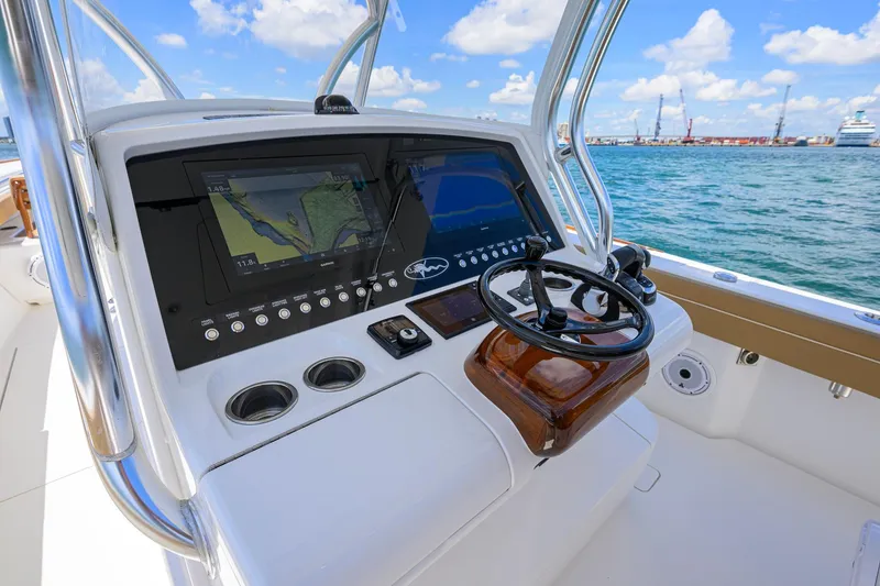 Slide: The Image of 2023 Valhalla Boatworks V-37 helm with advanced navigation displays on open water. - 12