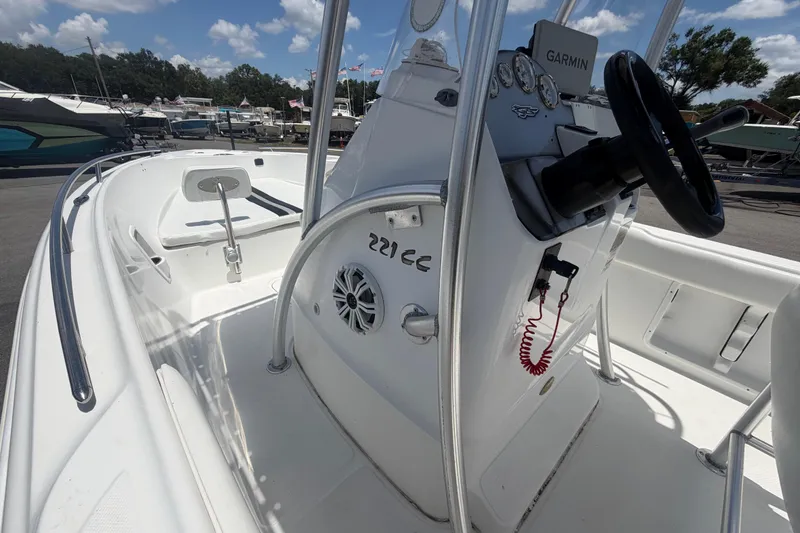Slide: The Image of 2012 Glasstream 221 CC boat interior with steering console and seating, docked under a clear sky. - 24