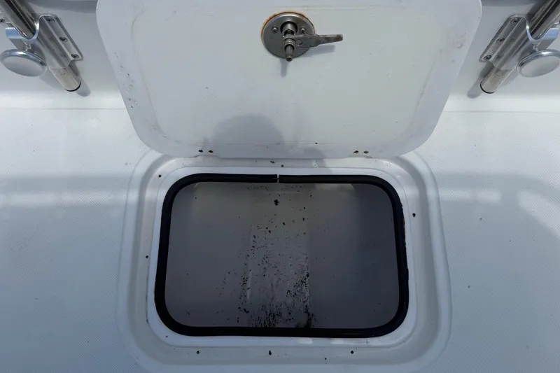 Slide: The Image of An open storage compartment on a boat with a metal handle. - 27