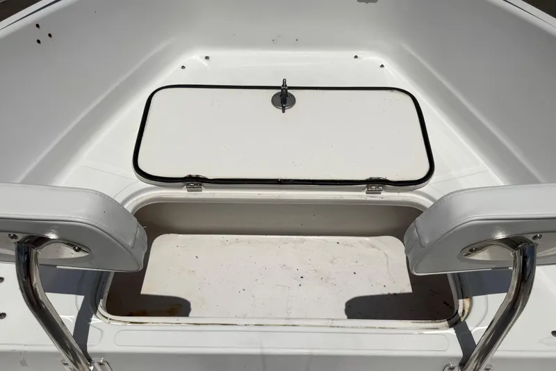 Slide: The Image of An open storage compartment on a boat with white upholstery and stainless steel handles. - 30