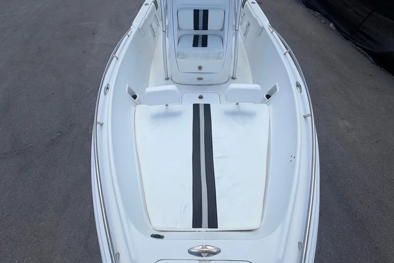 Slide: The Image of A white boat with black-striped seats, positioned on a dry dock. - 34