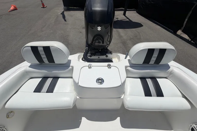 Slide: The Image of 2012 Glasstream 221 CC boat interior with dual seating and motor, parked on pavement. - 47