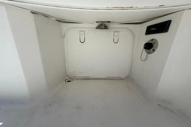 Slide: The Image of 2012 Glasstream 221 CC boat storage compartment with latch and fuel cap. - 55