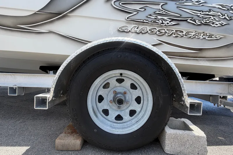 Slide: The Image of Trailer wheel of a 2012 Glasstream 221 CC boat, supported by concrete blocks. - 62
