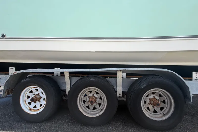 Slide: The Image of Trailer with three wheels supporting a 2018 NauticStar 28 XS boat. - 82