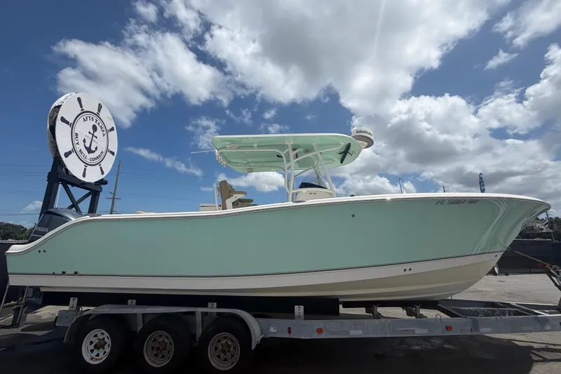 Slide: The Image of 2018 NauticStar 28 XS boat on trailer under cloudy sky. - 1