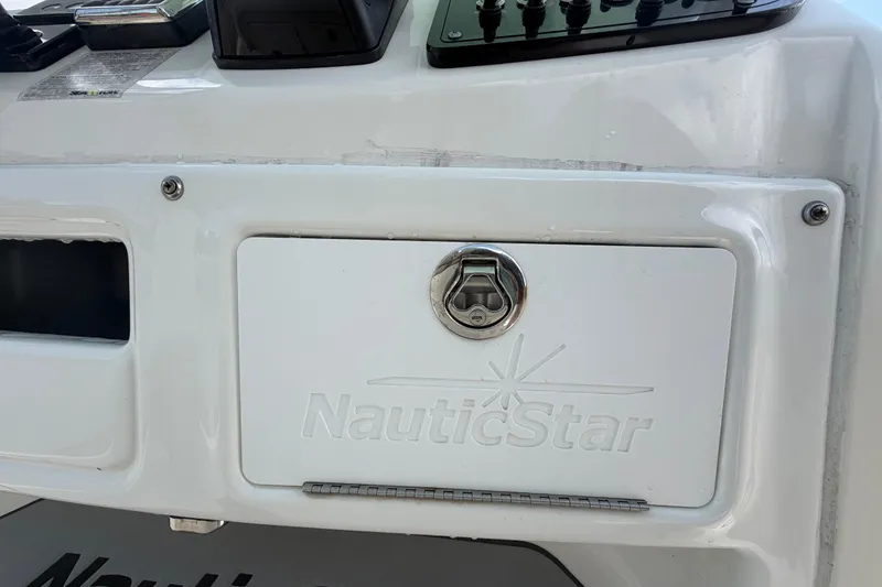 Slide: The Image of 2018 NauticStar 28 XS boat dashboard with storage compartment and control panel. - 39