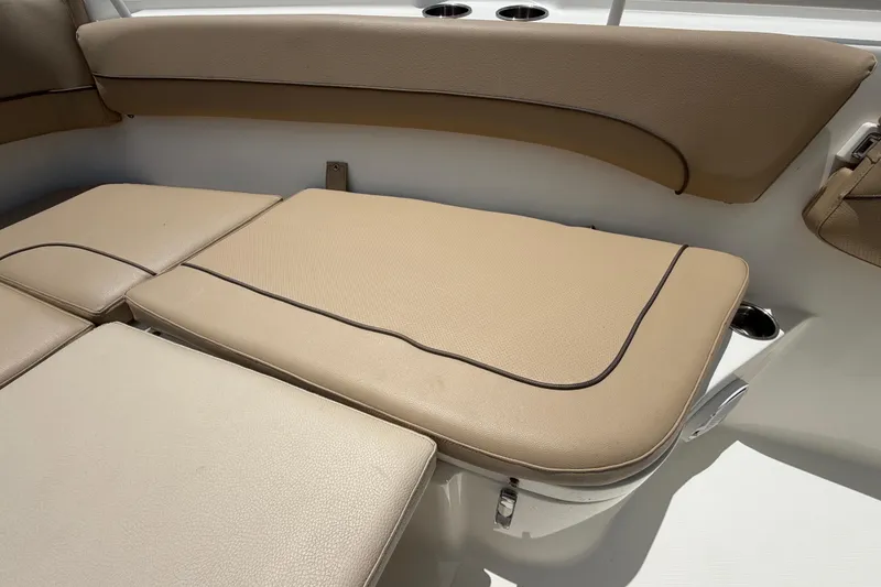 Slide: The Image of 2018 NauticStar 28 XS boat interior with tan cushioned seating. - 50