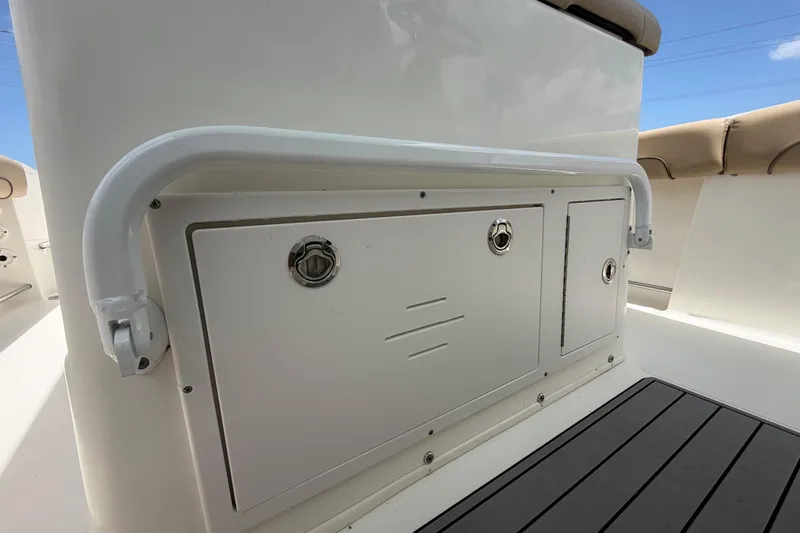 Slide: The Image of 2018 NauticStar 28 XS boat interior storage compartment with cushioned seating and railing. - 59