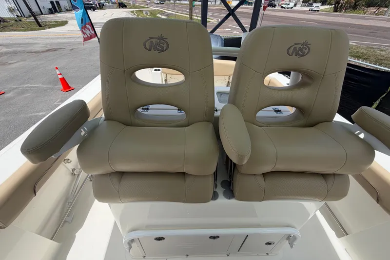 Slide: The Image of 2018 NauticStar 28 XS boat seats with armrests, featuring tan leather upholstery. - 63