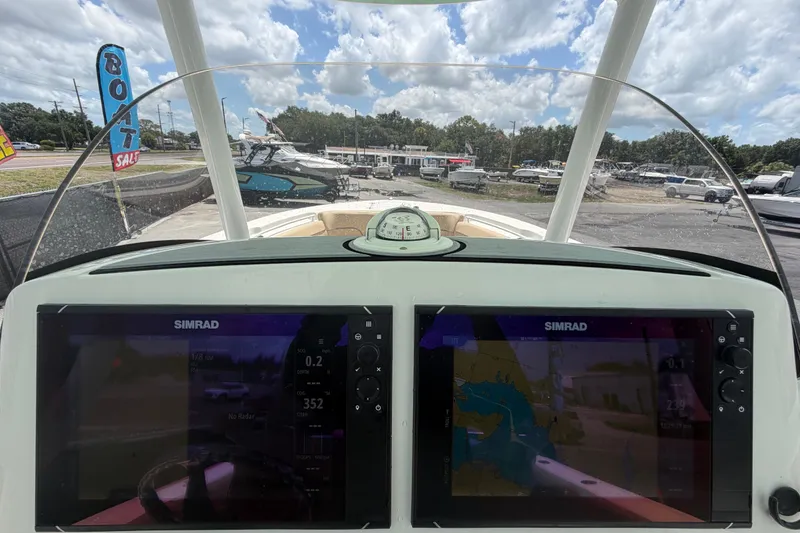 Slide: The Image of 2018 NauticStar 28 XS boat dashboard with dual Simrad displays, parked at a boat sale. - 30