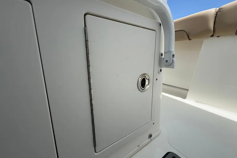 Slide: The Image of Storage compartment on a 2018 NauticStar 28 XS boat, featuring a secure latch. - 61