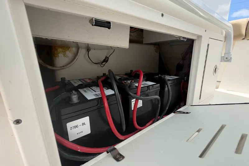 Slide: The Image of Battery compartment of a 2018 NauticStar 28 XS boat, featuring dual batteries and wiring. - 60