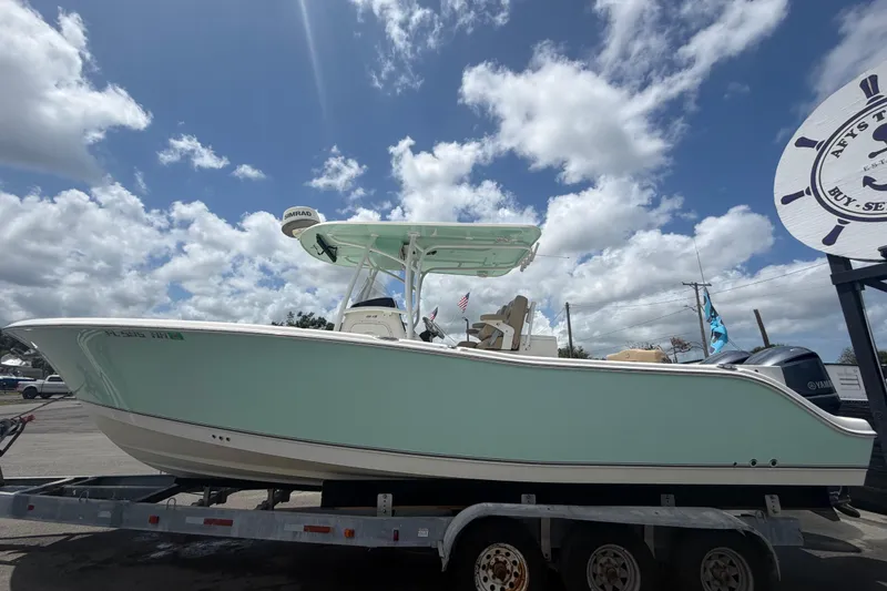 Slide: The Image of 2018 NauticStar 28 XS boat on trailer under cloudy sky. - 12