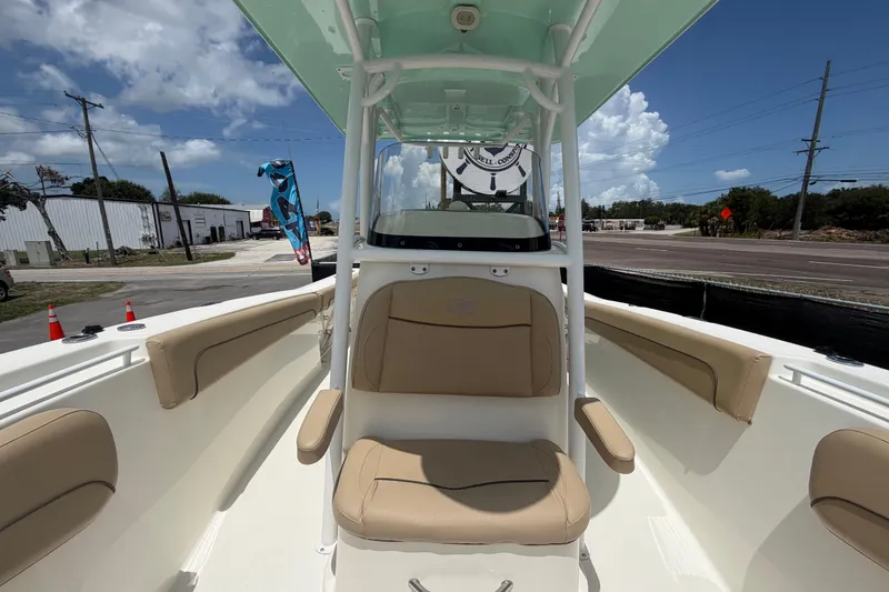 Slide: The Image of 2018 NauticStar 28 XS boat interior with tan seating and clear blue sky. - 56