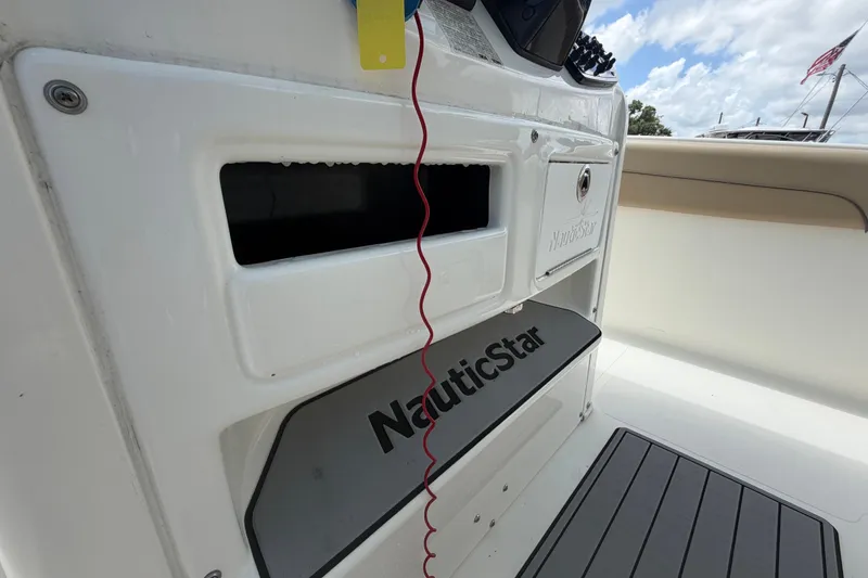 Slide: The Image of 2018 NauticStar 28 XS boat interior with storage compartment and branding. - 38