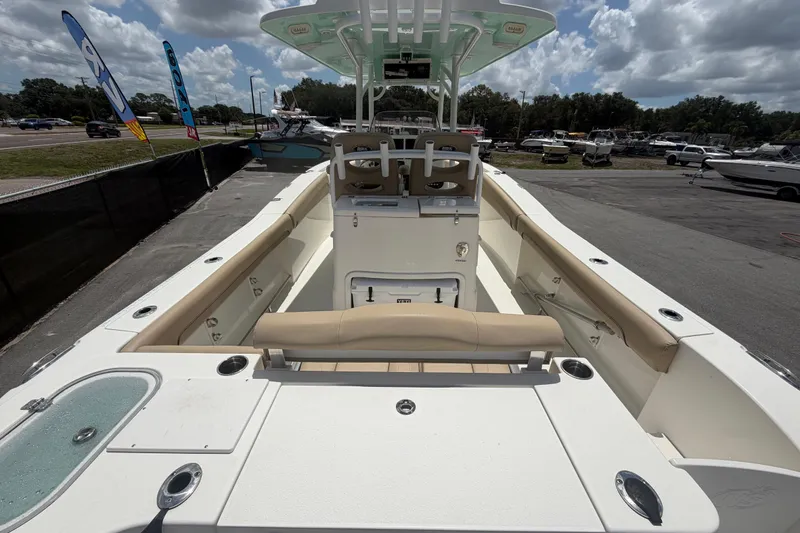 Slide: The Image of 2018 NauticStar 28 XS boat interior with seating and console, under a cloudy sky. - 16