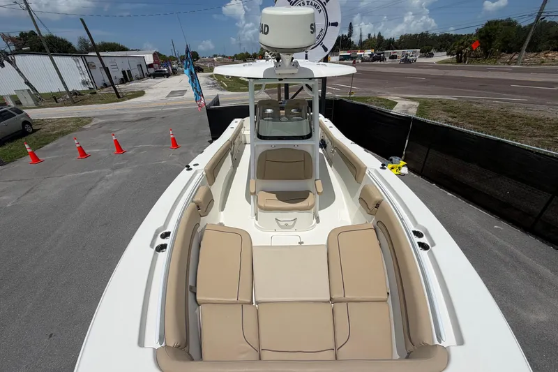 Slide: The Image of 2018 NauticStar 28 XS boat with beige seating, parked on a paved area under a clear sky. - 53