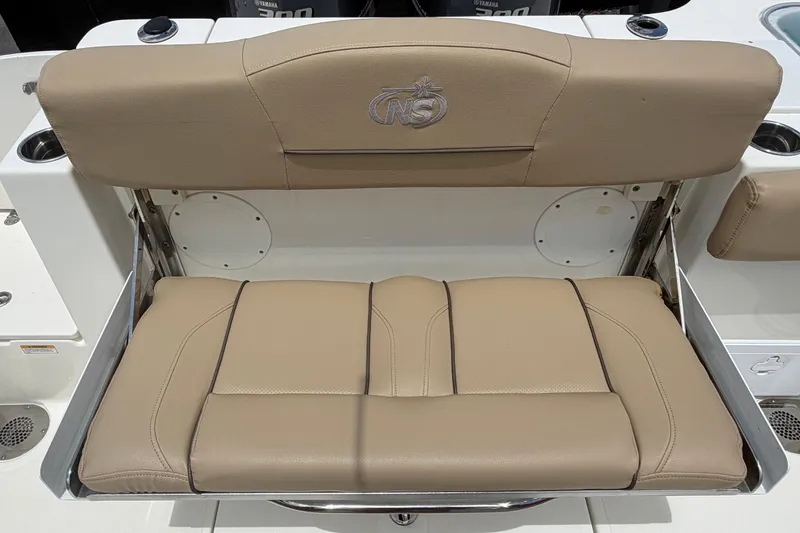 Slide: The Image of 2018 NauticStar 28 XS boat seat with tan upholstery and logo detailing. - 74