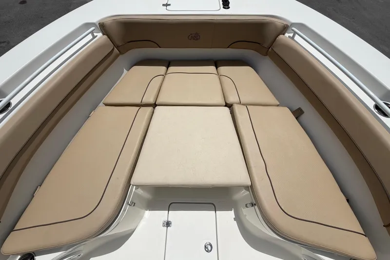 Slide: The Image of The image shows the bow area of a 2018 NauticStar 28 XS with beige cushions. - 47